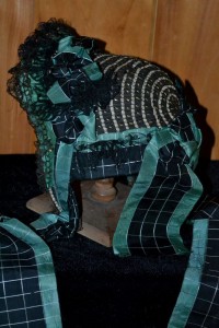 Woven ribbon curtain and ties over a straw bonnet.